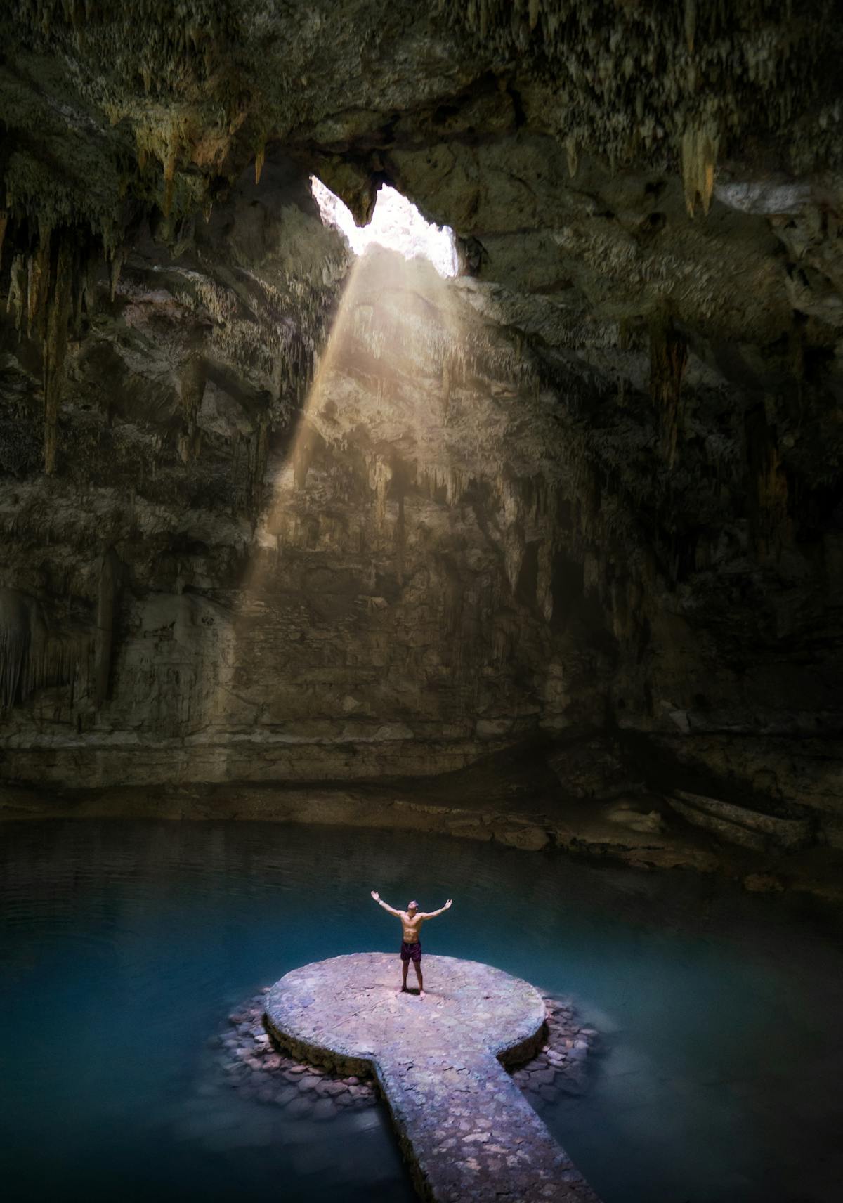 Cenote con rayo de luz iluminando las aguas cristalinas